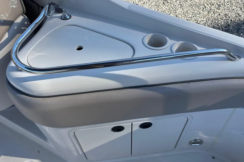 Slide: The Image of 2004 Sea Ray 240 Sundeck interior with cup holders and storage compartment. - 20