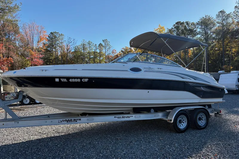 Slide: The Image of 2004 Sea Ray 240 Sundeck boat on trailer, surrounded by autumn trees. - 4