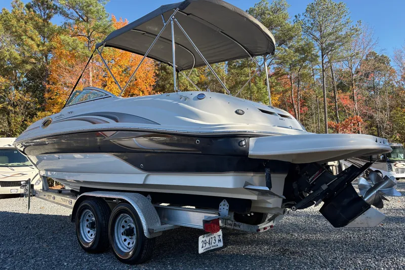 Slide: The Image of 2004 Sea Ray 240 Sundeck boat on trailer, surrounded by autumn trees. - 5