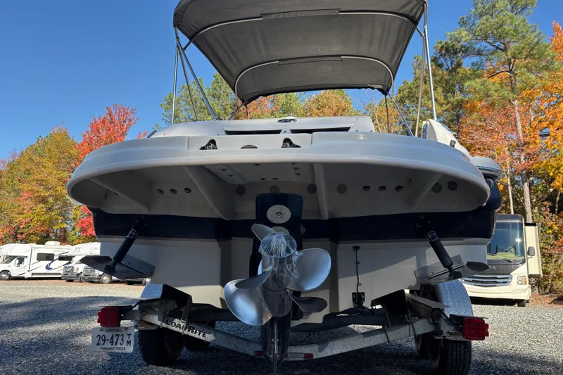 Slide: The Image of 2004 Sea Ray 240 Sundeck boat on trailer, surrounded by autumn trees. - 8
