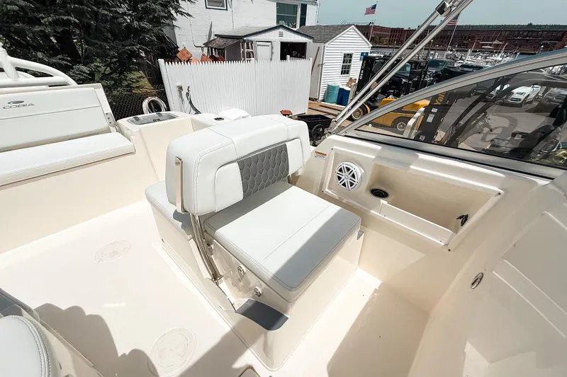 Slide: The Image of 2025 Cobia 220 Dual Console boat interior with white seating and speaker system. - 11