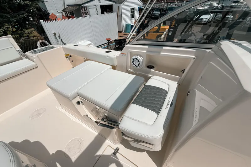 Slide: The Image of 2025 Cobia 220 Dual Console boat interior with cushioned seating and speaker. - 12
