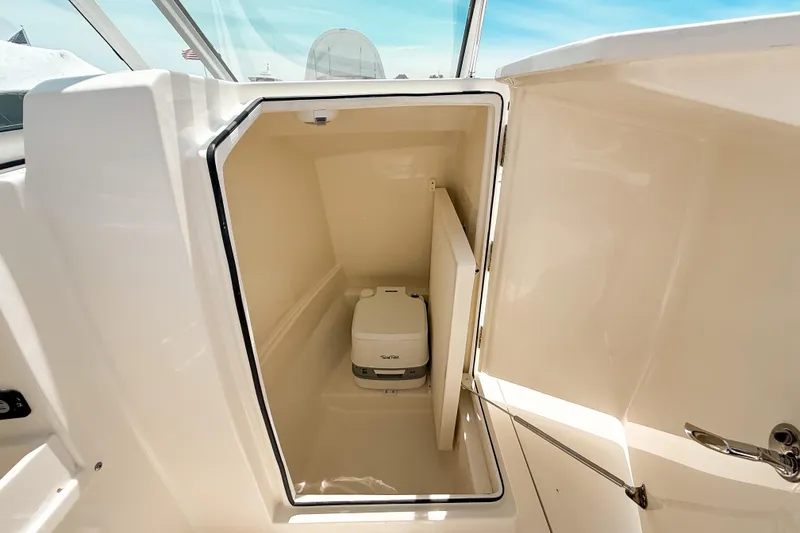 Slide: The Image of 2025 Cobia 220 Dual Console boat with onboard toilet compartment. - 13