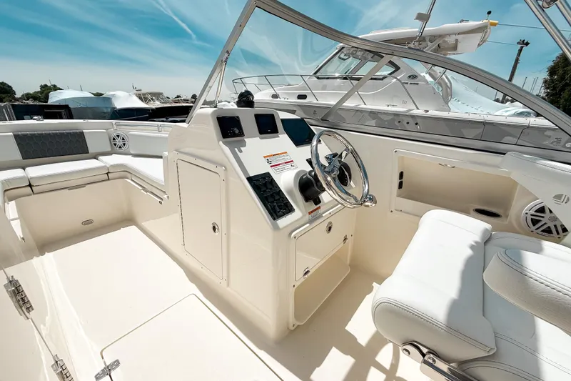 Slide: The Image of 2025 Cobia 220 Dual Console boat interior with steering wheel and seating. - 14