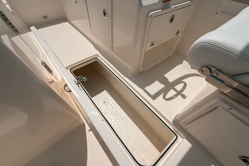 Slide: The Image of 2025 Cobia 220 Dual Console boat interior with open storage compartment. - 15