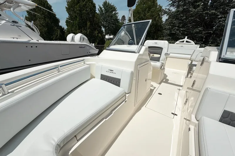 Slide: The Image of 2025 Cobia 220 Dual Console boat interior with white seating and sleek design. - 18