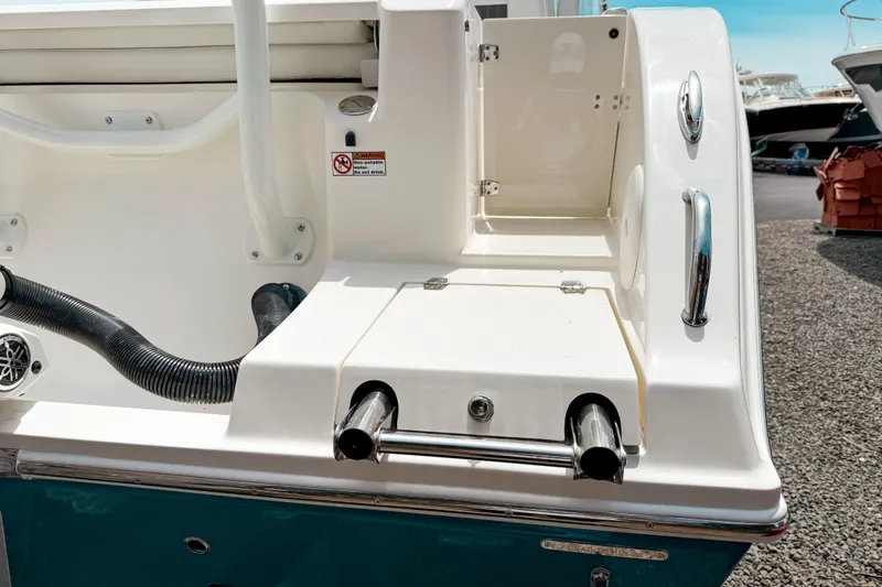 Slide: The Image of 2025 Cobia 220 Dual Console boat with swim ladder and storage compartment. - 3