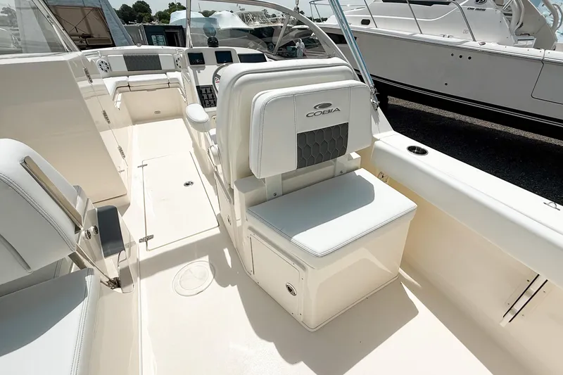 Slide: The Image of 2025 Cobia 220 Dual Console boat interior with white seating and modern dashboard. - 5