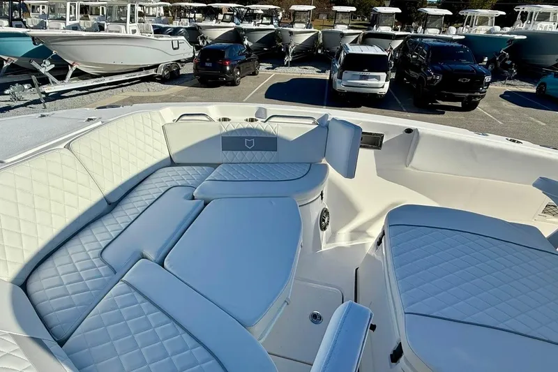 Slide: The Image of 2026 Sea Fox 268 Commander boat interior with luxurious seating and parked vehicles in the background. - 22