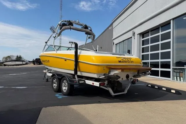 Slide: The Image of Yellow 2002 MasterCraft X30 boat on trailer outside a building. - 3