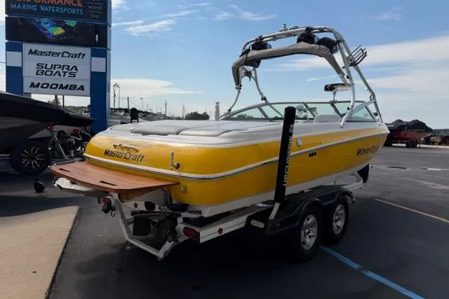 Slide: The Image of 2002 MasterCraft X30 boat in yellow, parked at a marine dealership. - 5