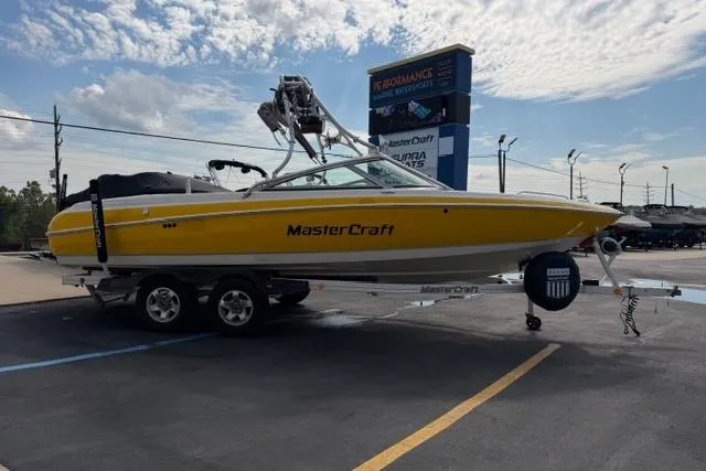 Slide: The Image of 2002 MasterCraft X30 boat in yellow, parked on a trailer at a dealership. - 6
