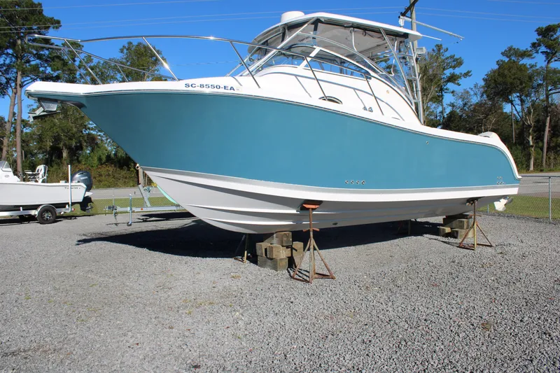 The Image of 2008 Pro-Line 29 Express O/B boat on stands, blue hull, outdoor setting. - 1