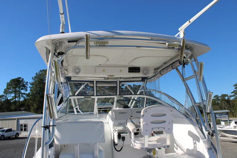 Slide: The Image of 2008 Pro-Line 29 Express O/B boat cockpit with seating and controls, under clear blue sky. - 18