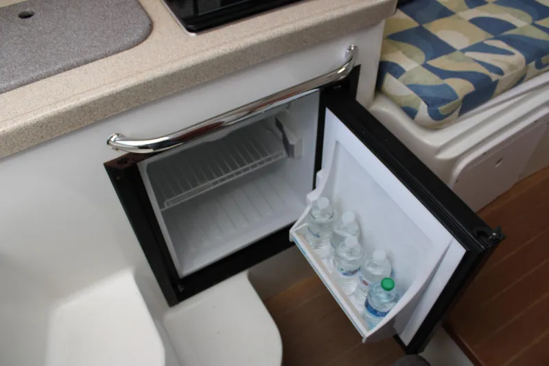 Slide: The Image of Compact fridge in 2008 Pro-Line 29 Express O/B boat interior, stocked with water bottles. - 30