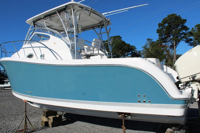 Slide: The Image of 2008 Pro-Line 29 Express O/B boat on stands, blue and white hull, outdoor setting. - 4