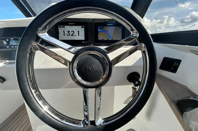 Slide: The Image of Steering wheel of 2022 Rand Supreme 27 boat with digital displays and controls. - 22