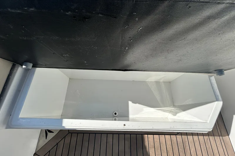 Slide: The Image of Rand Supreme 27 boat storage compartment, 2022 model, with wooden deck and black panel. - 56