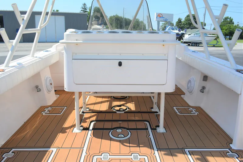 Slide: The Image of 2001 Intrepid 322 Cuddy boat interior with teak flooring and white console. - 13