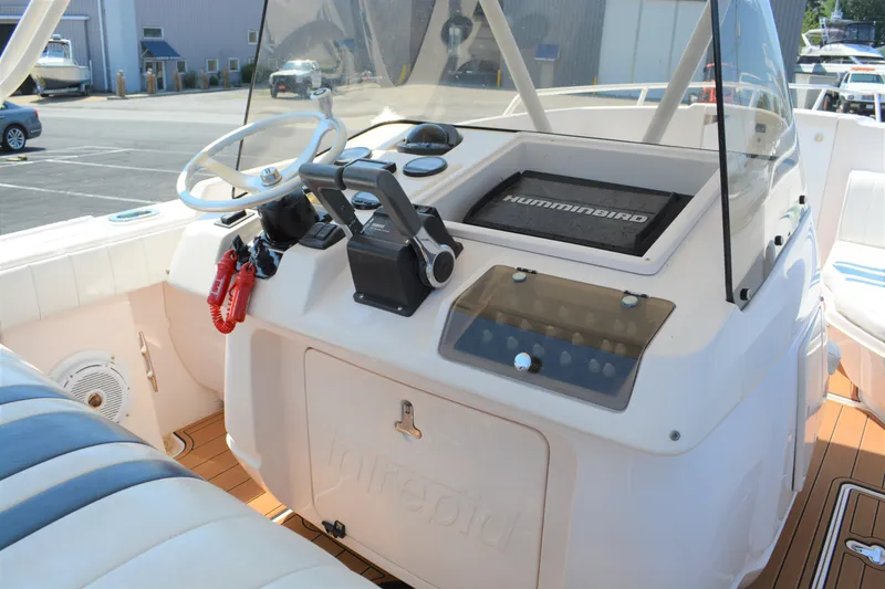 Slide: The Image of 2001 Intrepid 322 Cuddy boat helm with steering wheel and navigation equipment. - 16