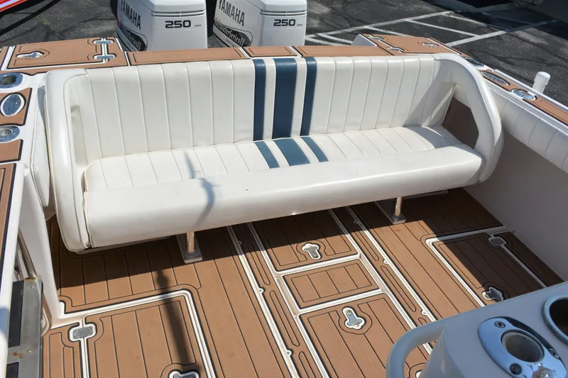 Slide: The Image of 2001 Intrepid 322 Cuddy boat with white seating and teak-style deck flooring. - 25