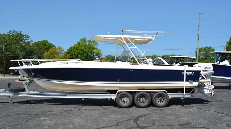 Slide: The Image of 2001 Intrepid 322 Cuddy boat on trailer, side view, outdoors. - 7