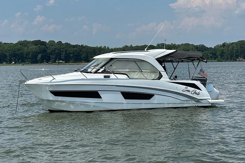 The Image of 2023 Beneteau Antares 9 boat on calm water, side view, with trees in the background. - 0