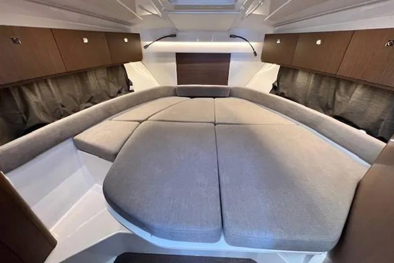Slide: The Image of 2023 Beneteau Antares 9 interior cabin with cozy bed and wooden storage cabinets. - 17