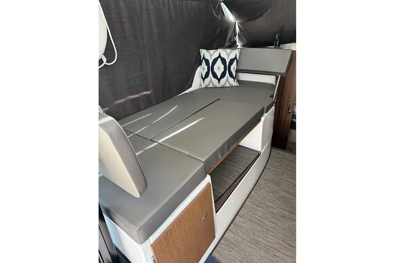 Slide: The Image of Interior of 2023 Beneteau Antares 9 with cushioned seating and decorative pillow. - 21