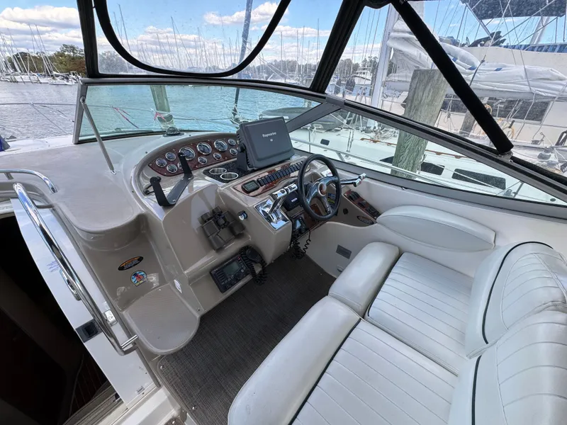 Slide: The Image of 2001 Maxum 3500 SCR boat cockpit with steering wheel, gauges, and white seating. - 14