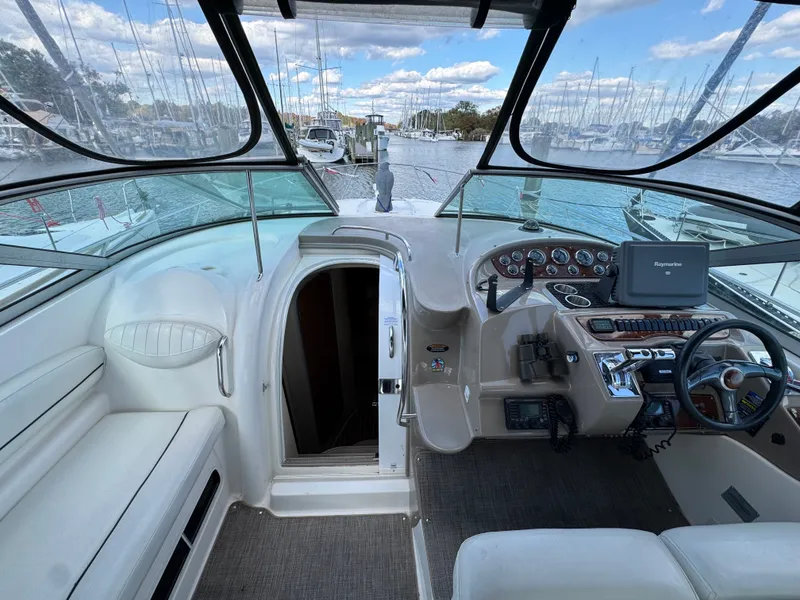Slide: The Image of 2001 Maxum 3500 SCR boat cockpit with steering wheel, navigation system, and marina view. - 15