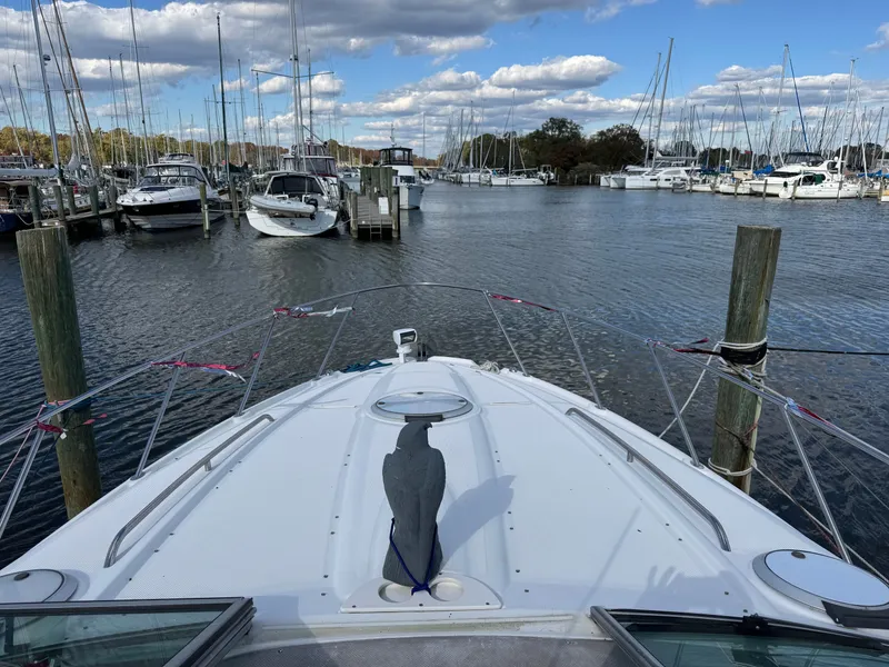 Slide: The Image of Bow view of 2001 Maxum 3500 SCR yacht docked in a marina under a cloudy sky. - 16