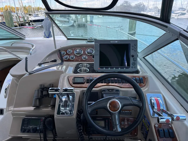 Slide: The Image of 2001 Maxum 3500 SCR boat helm with steering wheel, navigation controls, and marine electronics. - 3