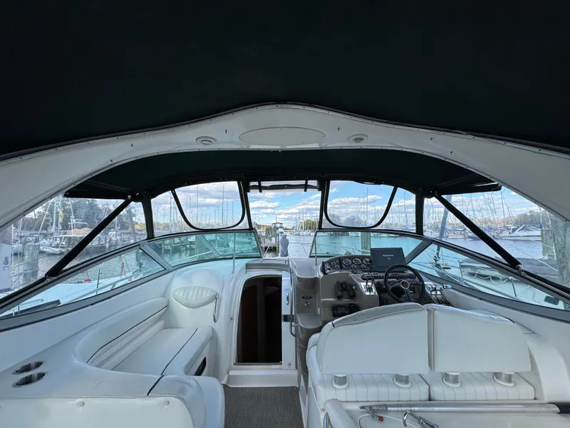 Slide: The Image of 2001 Maxum 3500 SCR yacht interior with helm, white seating, and marina view. - 33