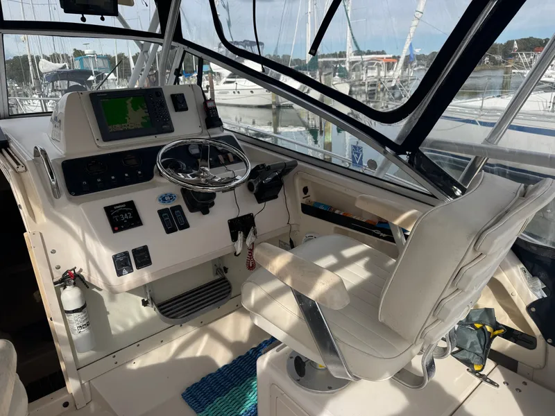 Slide: The Image of 2004 Grady-White Marlin 300 helm with steering wheel, navigation equipment, and captain's chair. - 11
