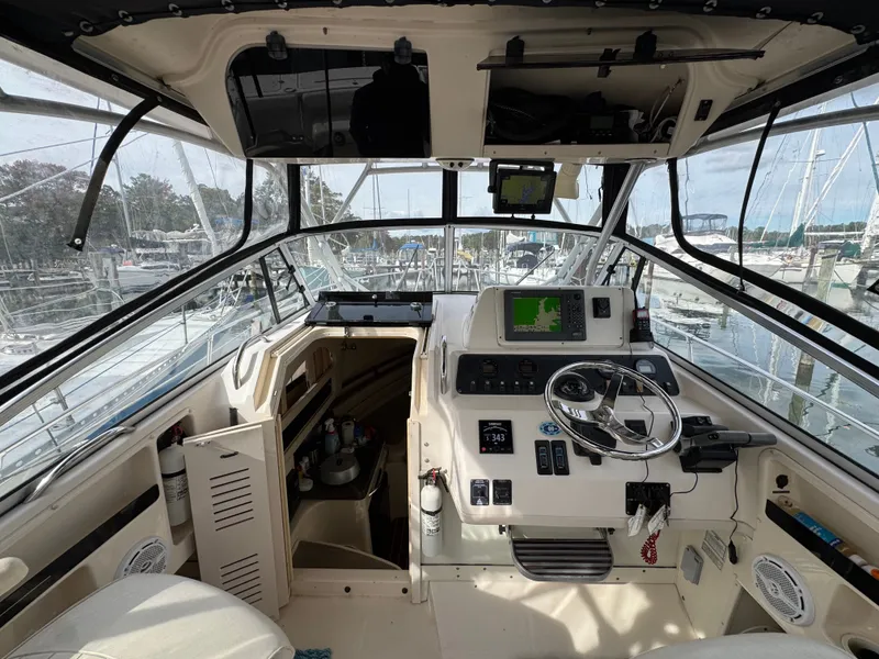Slide: The Image of 2004 Grady-White Marlin 300 boat cockpit with navigation equipment and marina view. - 12