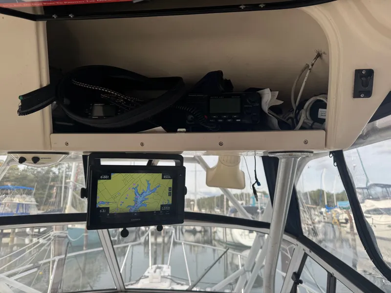 Slide: The Image of 2004 Grady-White Marlin 300 boat cockpit with navigation equipment and marina view. - 14