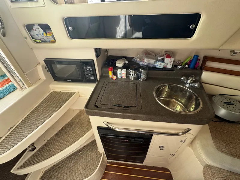 Slide: The Image of 2004 Grady-White Marlin 300 boat interior with kitchenette, sink, and microwave. - 20