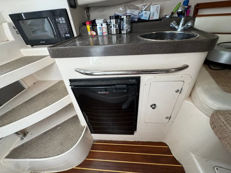 Slide: The Image of 2004 Grady-White Marlin 300 boat galley with microwave, sink, and mini fridge. - 21