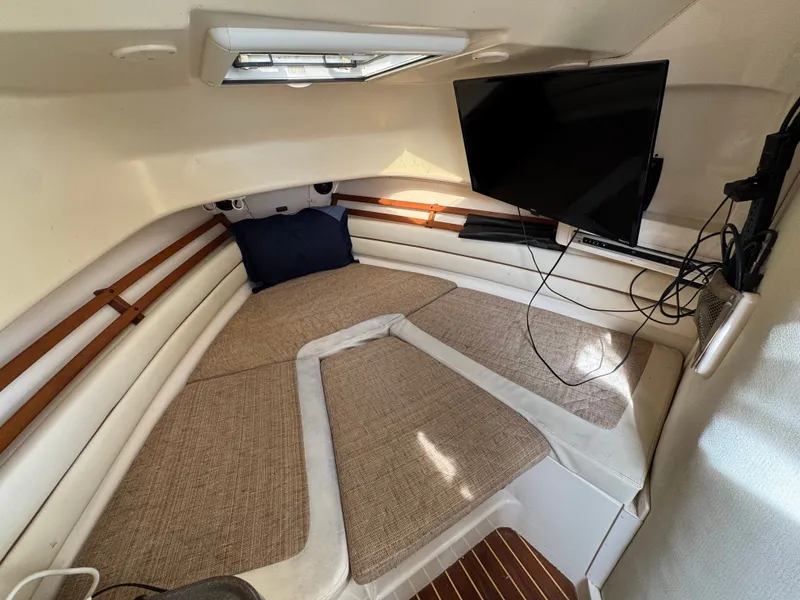 Slide: The Image of Cozy cabin interior of 2004 Grady-White Marlin 300 with TV and cushioned seating. - 22