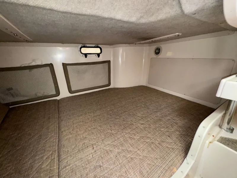 Slide: The Image of 2004 Grady-White Marlin 300 cabin interior with cushioned sleeping area and storage nets. - 27