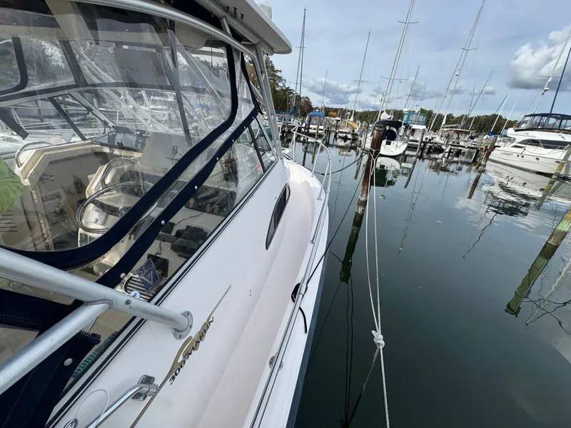 Slide: The Image of 2004 Grady-White Marlin 300 boat docked in a marina, surrounded by calm waters. - 29
