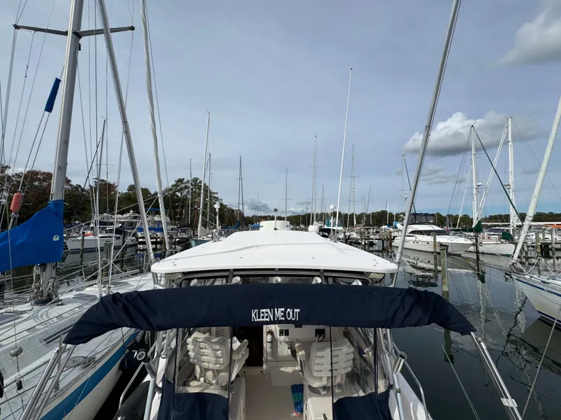Slide: The Image of 2004 Grady-White Marlin 300 boat docked in a marina, surrounded by sailboats. - 8