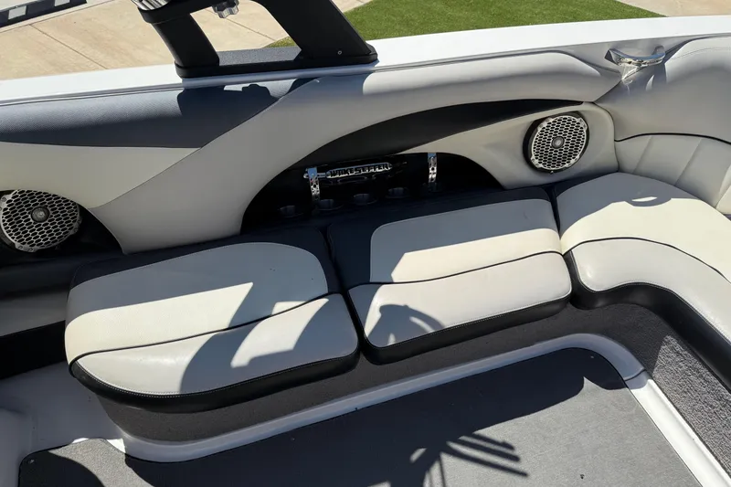 Slide: The Image of 2011 Malibu Wakesetter 247 LSV interior with white and black seating, speakers, and cup holders. - 16