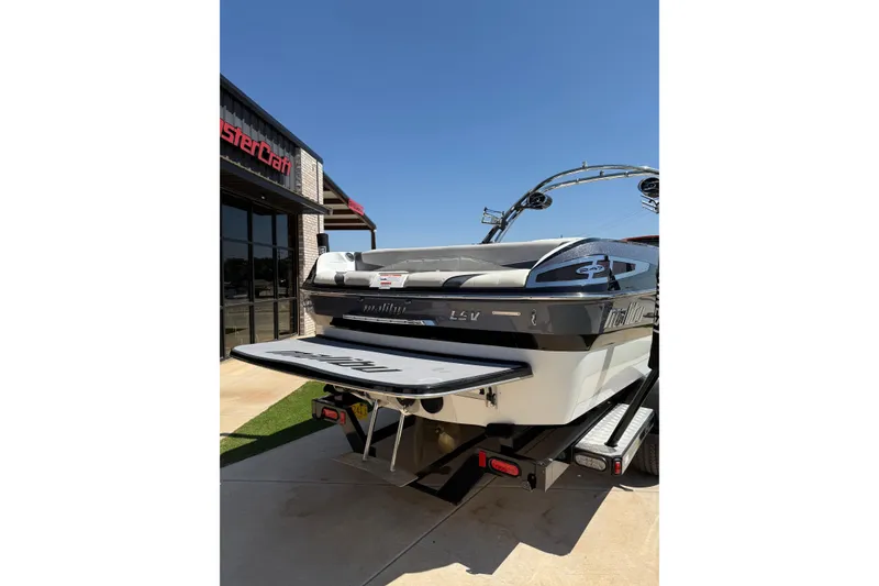 Slide: The Image of 2011 Malibu Wakesetter 247 LSV boat on trailer, parked outside dealership. - 4