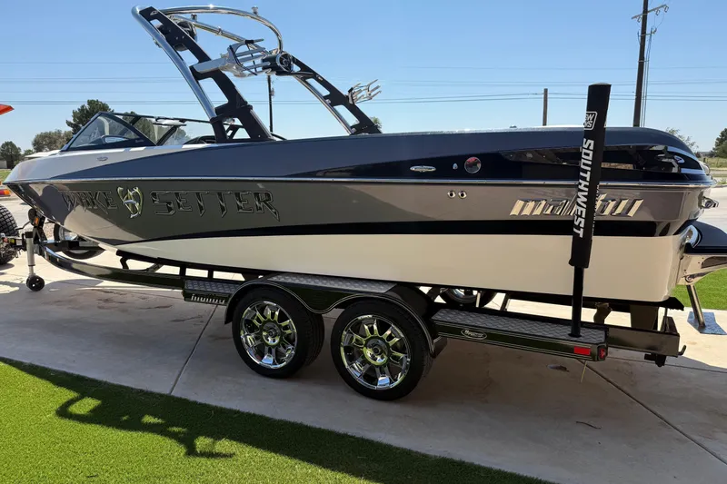 Slide: The Image of 2011 Malibu Wakesetter 247 LSV boat on trailer, sleek design, chrome wheels. - 7