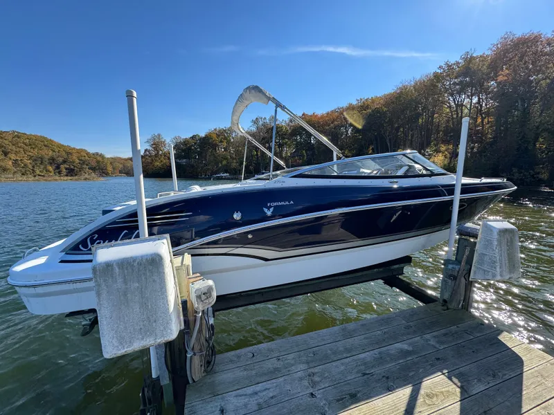 Slide: The Image of 2014 Formula 270 Bowrider boat docked on a sunny lake with autumn trees. - 3