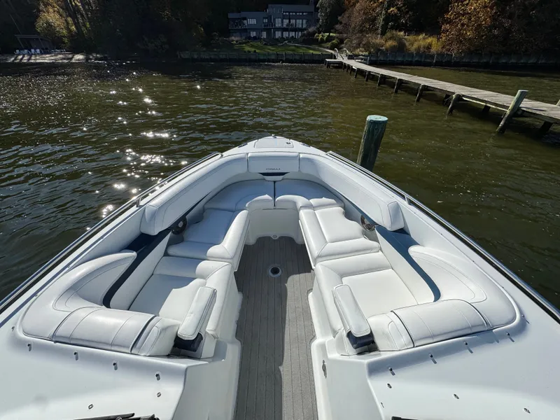 Slide: The Image of 2014 Formula 270 Bowrider boat with spacious seating, docked by a serene waterfront. - 5