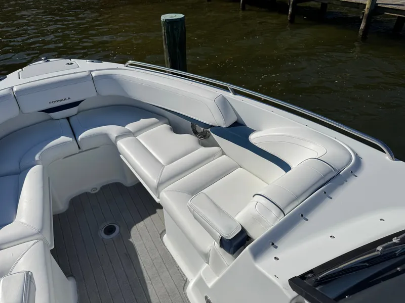 Slide: The Image of 2014 Formula 270 Bowrider boat with white seating, docked by the water. - 7