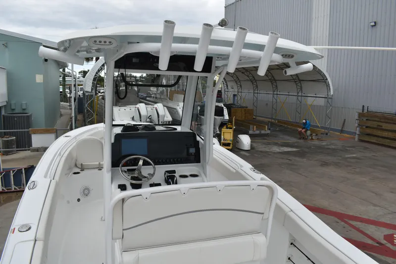 Slide: The Image of 2023 Sea Hunt Ultra 255 SE boat interior with steering console and rod holders. - 15